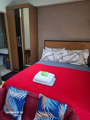 a bedroom with a red bed with two towels on it at MRMCONDOTEL cluster 1 2H in Manila