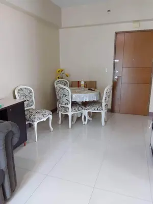 a dining room with a table and chairs in a room at MRMCONDOTEL in Manila