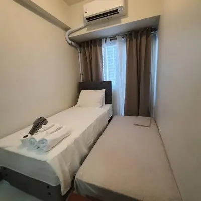 a small room with a bed with towels on it at SMDC Coast Residences Lovely Fully-furnished 1 BR Condo with pool in Manila