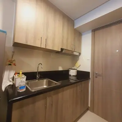 a kitchen with a sink and wooden cabinets at SMDC Coast Residences Lovely Fully-furnished 1 BR Condo with pool in Manila