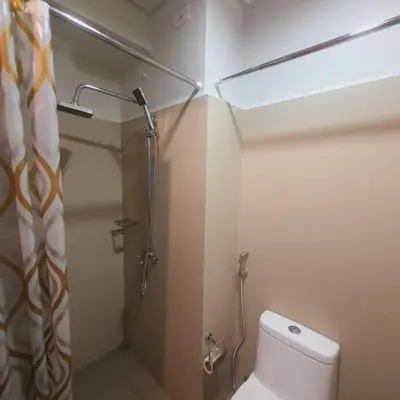 a small bathroom with a toilet and a shower at SMDC Coast Residences Lovely Fully-furnished 1 BR Condo with pool in Manila