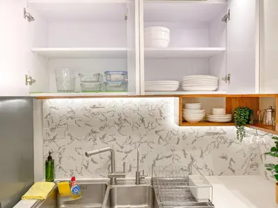 a kitchen with a sink and white cabinets at Large 1-Bedroom Condo 60sqm Makati Rockwell CBD Poblacion in Manila