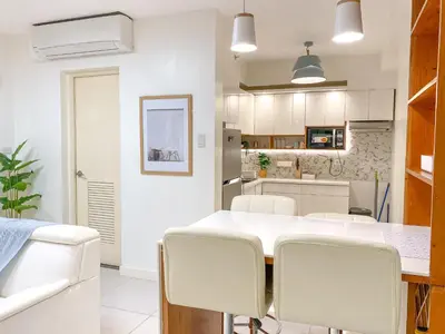 a kitchen with a white table and chairs at Large 1-Bedroom Condo 60sqm Makati Rockwell CBD Poblacion in Manila