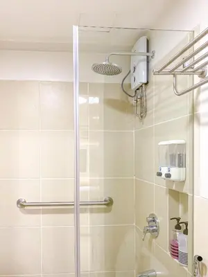 a bathroom with a shower with a glass door at Large 1-Bedroom Condo 60sqm Makati Rockwell CBD Poblacion in Manila