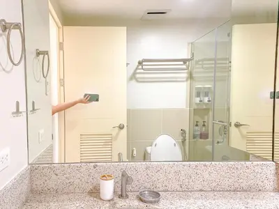 a person taking a picture of a bathroom with a shower at Large 1-Bedroom Condo 60sqm Makati Rockwell CBD Poblacion in Manila