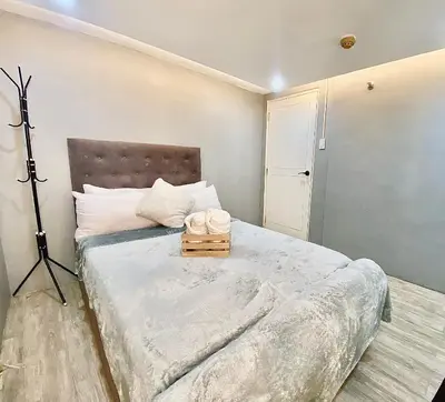a bedroom with a large bed with a tripod at IV’s Condo w/ Netflix, Wifi & Karaoke in Cainta