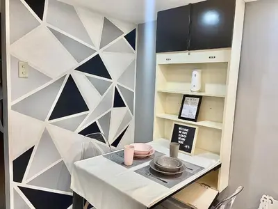 a kitchen with a white table and a wall at IV’s Condo w/ Netflix, Wifi & Karaoke in Cainta