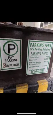 two parking signs on the side of a building at IV’s Condo w/ Netflix, Wifi & Karaoke in Cainta