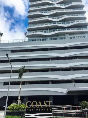 a tall building with a coast residence sign in front of it at StayInMyCondo - 8th Condo in Pasay near NAIA Airport, MOA Pasay in Manila