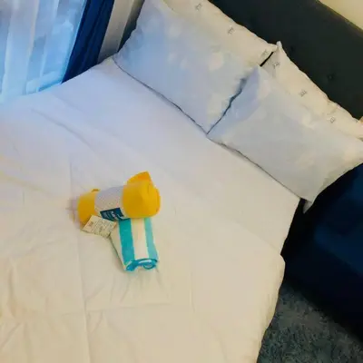 a white bed with a stuffed animal on it at Avida Tower Sucat, comfortable studio type in Manila