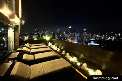 a row of beds on a balcony with a city skyline at the Gramercy Residences NEW RELEASE in Manila