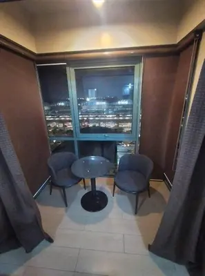 a room with a table and two chairs and a window at RQUI CONDOTEL NEWPORT PASAY in Manila