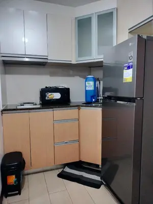 a kitchen with a stainless steel refrigerator and cabinets at RQUI CONDOTEL NEWPORT PASAY in Manila