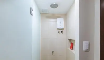 a bathroom with a shower with white tiles at RedDoorz Plus near Nakpil St Taft Avenue in Manila