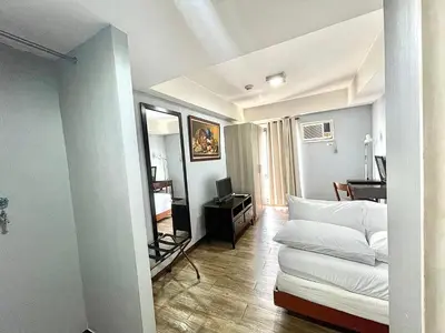 a living room with a white couch and a desk at CEO Flats in Manila