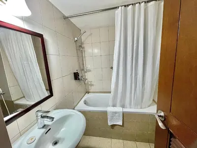 a bathroom with a sink and a tub with a shower curtain at CEO Flats in Manila