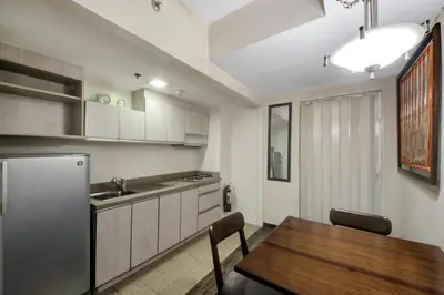 a kitchen with a table and a refrigerator at CEO Flats in Manila