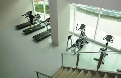 a woman running on treadles in a gym at Beacon Makati Condo Free POOL Access FREE WIFI 100mbps & FREE Netflix in Manila