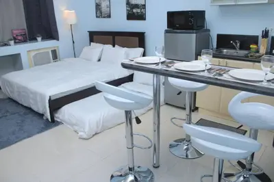 a hotel room with a bed and a table and chairs at A2J Executive Studio Suite Near Venice Mall BGC in Manila