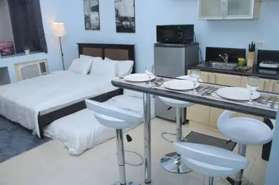 a hotel room with a bed and a table and chairs at A2J Executive Studio Suite Near Venice Mall BGC in Manila