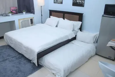 a bedroom with a large white bed and a pillow at A2J Executive Studio Suite Near Venice Mall BGC in Manila
