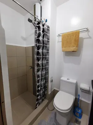 a bathroom with a toilet and a shower at Ethan's Pad Nr. BGC in Manila