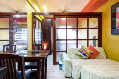 a living room with a couch and a table at BalaiB1 Cozy Studio in Ortigas Center in front of Galleria in Manila