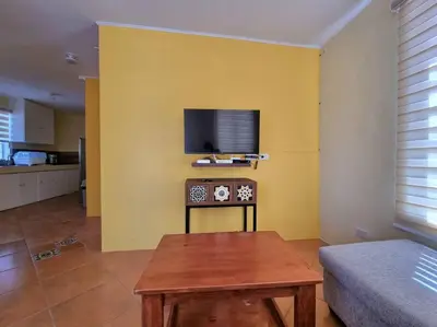 a living room with a tv on a yellow wall at #30 Bel Air House by Red Door House Rental in Santa Rosa