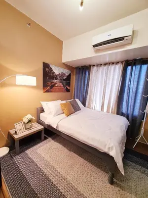 a bedroom with a bed and a air conditioner at Staycation by Ness in Ayala Makati in Manila
