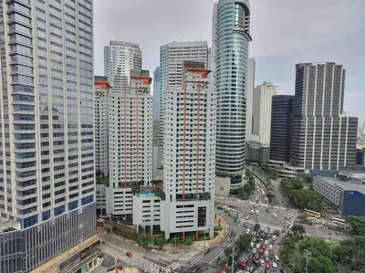 a city skyline with tall buildings and a street with cars at Staycation by Ness in Ayala Makati in Manila