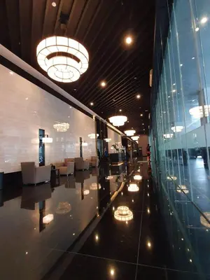 a lobby of a building with chairs and a glass wall at Staycation by Ness in Ayala Makati in Manila
