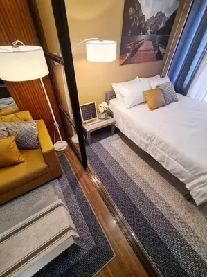a bedroom with a bed and a chair and a window at Staycation by Ness in Ayala Makati in Manila