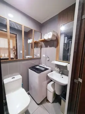 a bathroom with a white toilet and a sink at Staycation by Ness in Ayala Makati in Manila