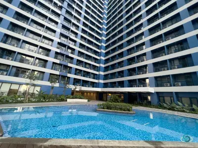 a swimming pool in front of a large building at Staycation by Ness in Ayala Makati in Manila