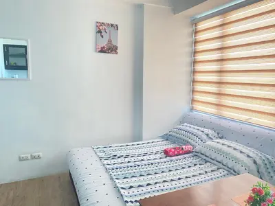 a blue couch in a room with a window at affordable staycation alabang in Manila