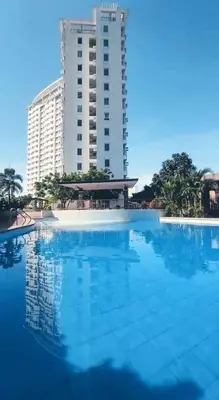 a large swimming pool in front of a tall building at affordable staycation alabang in Manila