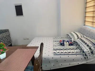 a small room with a bed and a table and a table and a table at affordable staycation alabang in Manila