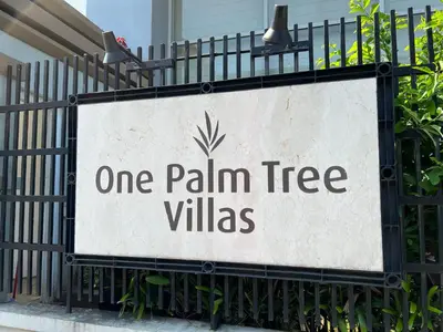a sign that reads one palm tree villas on a fence at Telly's Studio Across NAIA3 in Manila