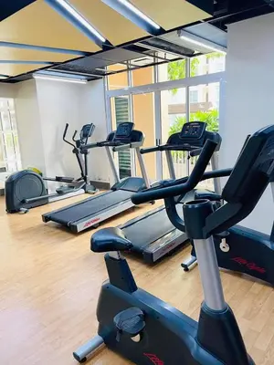a gym with several tread machines in a room at Premium Executive Suite at Venice Luxury Residences in Manila