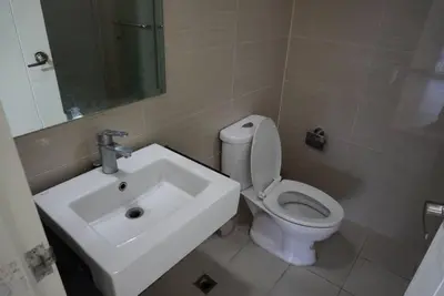 a bathroom with a white toilet and a sink at Premium Executive Suite at Venice Luxury Residences in Manila