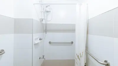 a white bathroom with a shower and a toilet at RedDoorz @ Melbourne Suites Makati in Manila