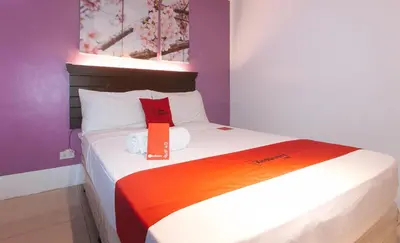 a bedroom with a bed with an orange flag on it at RedDoorz @ Melbourne Suites Makati in Manila