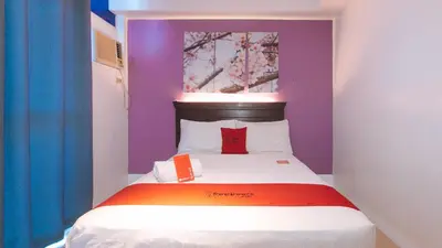 a small room with a bed with colorful walls at RedDoorz @ Melbourne Suites Makati in Manila