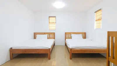 two beds in a room with white walls and windows at RedDoorz @ Alquiza Residences Paranaque in Manila