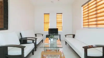 a living room with white couches and a glass table at RedDoorz @ Alquiza Residences Paranaque in Manila