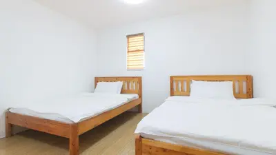 two twin beds in a room with white walls at RedDoorz @ Alquiza Residences Paranaque in Manila