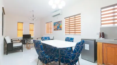 a kitchen with blue chairs and a white table at RedDoorz @ Alquiza Residences Paranaque in Manila
