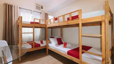 two bunk beds in a room with a glass table at RedDoorz Plus @ Cuarto Verde Staycation in Manila