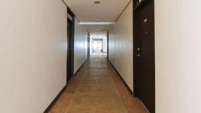 a hallway with white walls and a long hallway with black doors at RedDoorz Plus @ Cuarto Verde Staycation in Manila