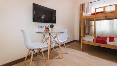 a room with a table and chairs and a bunk bed at RedDoorz Plus @ Cuarto Verde Staycation in Manila